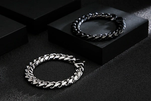 Detailed view of silver and black stainless steel Cuban link chains on display blocks