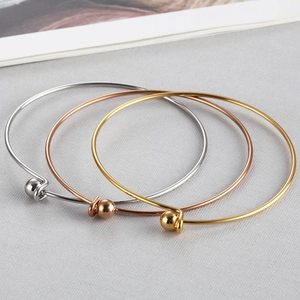 Three minimalist polished stainless steel open bangles in gold, rose gold and silver colors