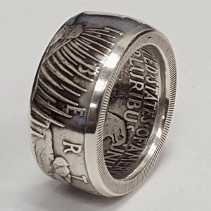 Macro detail of retro silver dollar coin ring with Liberty and eagle relief patterns