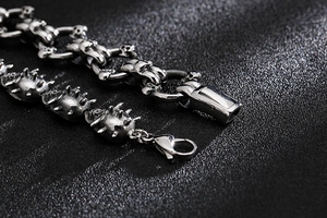 Détail macro du bracelet à crânes gothique avec fermoir mousqueton et texture à épines