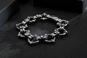 Gros plan d'un bracelet punk tête de mort en acier inoxydable argent mat sur fond noir