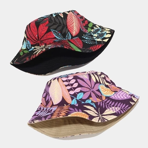 Detail view of double-sided canvas bucket hats with vibrant tropical floral patterns