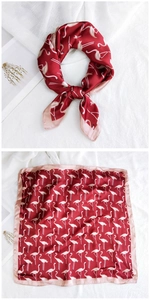 Detail of burgundy satin square scarf featuring elegant pink flamingo prints and silky texture