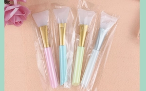 Detailed view of four silicone face mask brushes in individual clear plastic packaging