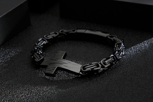 Detailed view of a black Byzantine chain bracelet featuring a cross-shaped metal plaque