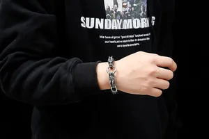 Gros plan détaillé d'un bracelet gourmette argenté tête de dragon pour homme style gothique