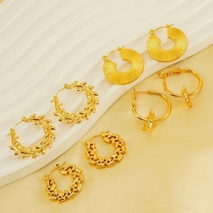 Macro shot of four gold geometric earrings with fan, leaf, and chain texture patterns
