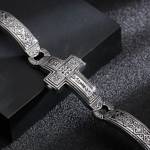 Punk vintage stainless steel cross bracelet with geometric relief on black pedestal