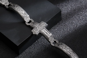 Macro detail of retro stainless steel cross bracelet with antique silver finish carvings
