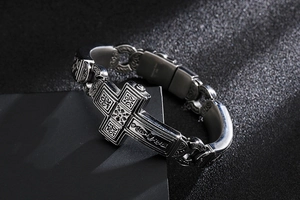 Macro shot of retro stainless steel cross bracelet with detailed embossed textures