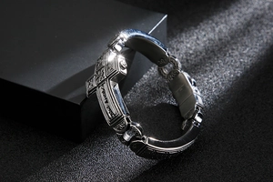 Detailed view of silver stainless steel bracelet featuring punk cross and floral engravings