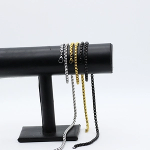 Detail of stainless steel box chains in silver, gold, and black colors on display