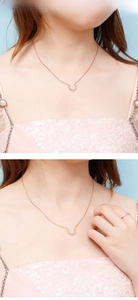 Detail of C-shaped horseshoe necklace and ring set with sparkling zircon stones