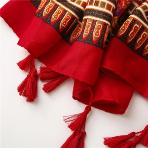 Detail of red bohemian cotton scarf with ethnic geometric patterns and tassel edges