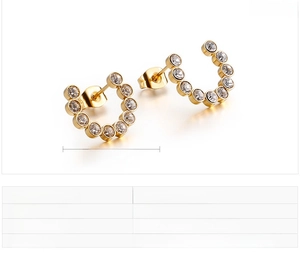 Detail showing gold C-shaped earrings inlaid with sparkling round zircon stones