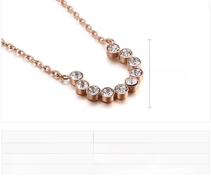 Detailed view of U-shaped gold necklace with zircon pendants and size specifications