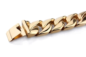 Macro view of gold stainless steel Cuban chain bracelet with a secure slide clasp