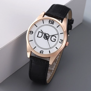 Minimalist quartz watch with rose gold case and black crocodile leather strap on grey background