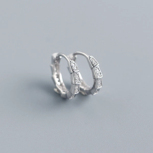 Macro shot of S925 sterling silver snake scale hoop earrings with sparkling cubic zirconia