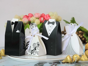Detailed view of bride and groom wedding favor boxes on a white ceramic plate