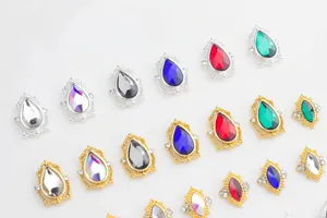 Macro shot of colorful teardrop nail crystals with gold and silver alloy frames