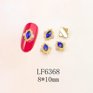 Detail of dark blue marquise crystal nail art charm with tiny diamonds on red nails