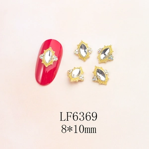 Detailed macro of vintage baroque nail art charms with crystal marquis and gold trim