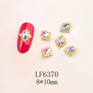 Macro detail of alloy nail charms with golden base and 8x10mm iridescent teardrop gems