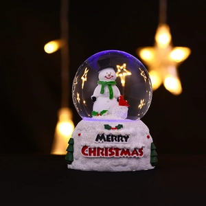Gros plan d'une boule à neige bonhomme de neige lumineuse avec texte Merry Christmas 3D