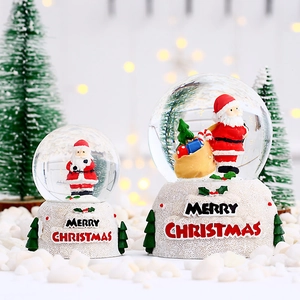 Boule à neige lumineuse de Noël avec Père Noël sur socle en résine effet neige