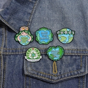 Set of five creative green Earth day enamel pins on blue denim jacket pocket