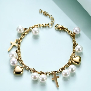 Detailed view of golden chain bracelet with white pearls, polished hearts, and cross charms