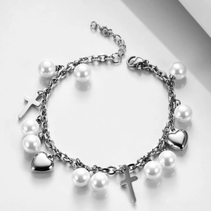 Macro view of stainless steel bracelet with silver heart, pearl and cross charms