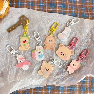 Flat lay of cute acrylic cartoon bear and rabbit keychains with colorful plastic hooks