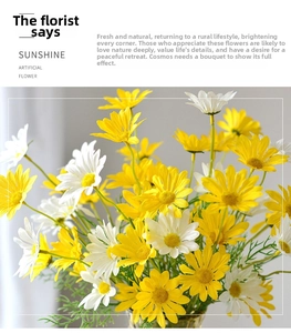 Detail of realistic yellow and white artificial daisies with rich fabric petals and green leaves