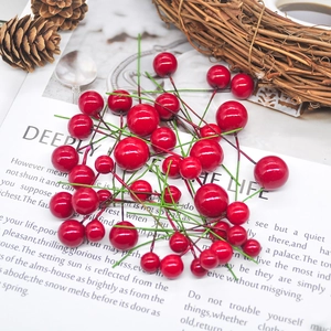 Red Christmas berry picks with pine cones on rustic background for festive decor