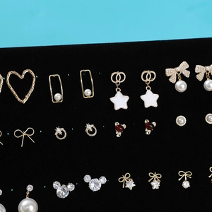 Detailed view of assorted gold earrings displayed on a black velvet jewelry board