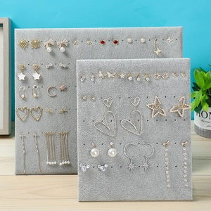 Gray velvet L-shaped earring display stands showcasing various studs and jewelry