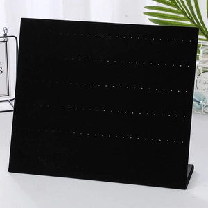 Close-up of black velvet earring display stand with multiple holes for jewelry organization