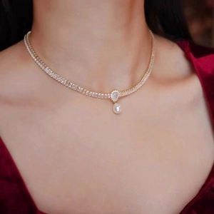 Collana girocollo dorata con zirconi brillanti e pendente di perla barocca a goccia