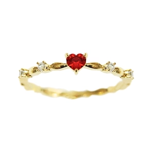 Elegant gold ring featuring a heart-shaped red zircon with twisted band design