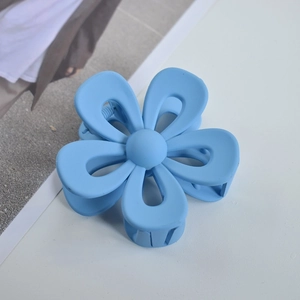 Macro shot of the blue matte flower hair claw clip with its durable grip teeth design