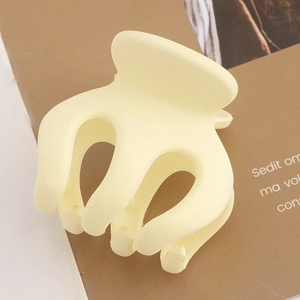 Matte cream large pumpkin hair claw clip for elegant updo hairstyles on brown background