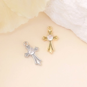Macro shot of gold and silver cross pendants with round cubic zirconia center stones