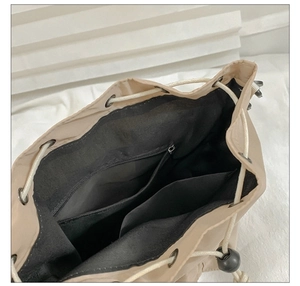Interior detail of nylon bucket bag showing black lining and zip pocket storage