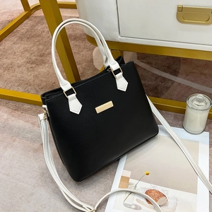 Classic black and white contrast leather handbag with gold metal accents and shoulder strap