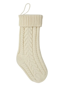 Detail of cream cable knit Christmas stocking with soft wool texture and hanging loop