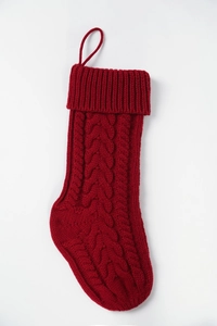 Detail of red cable knit Christmas stocking with folded cuff and hanging loop texture