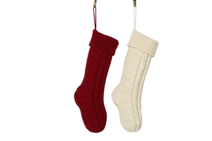 Detail of red and cream knitted Christmas stockings with classic cable stitch patterns