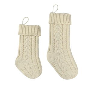 Detailed close-up of cream knit Christmas stockings with classic cable stitch patterns